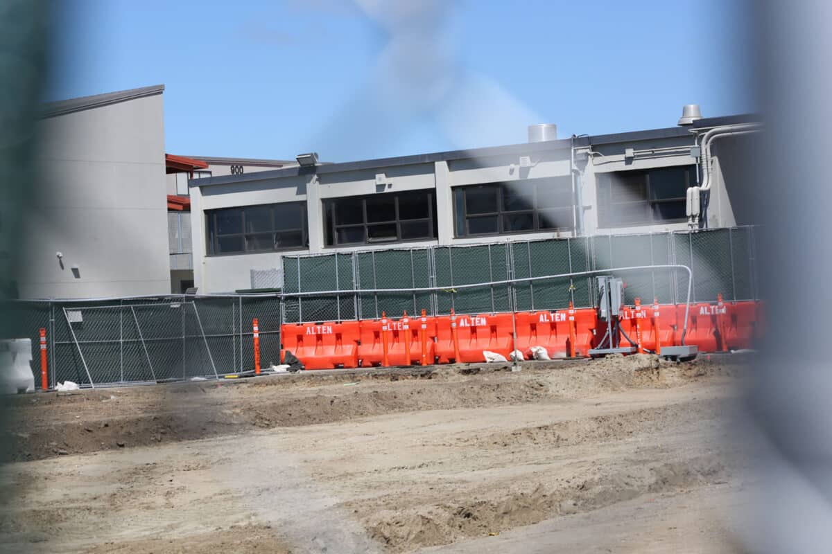 Alameda Post - A photo through a chain link fence of a construction site. 