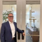 Alameda Post - Alameda's new City Manger Gerry Beaudin stands by the City Manager door in city hall and smiles.