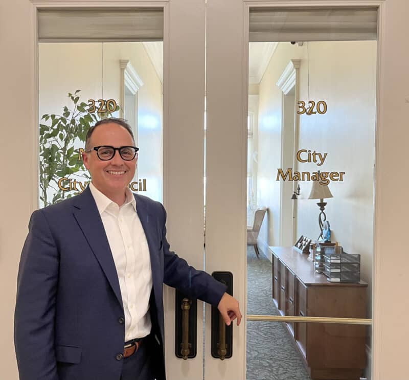 Alameda Post - Alameda's new City Manger Gerry Beaudin stands by the City Manager door in city hall and smiles.