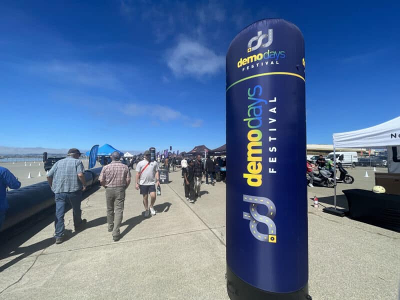 Alameda Post - Attendees walk outdoors at Alameda Point towards the Demo Days Festival exposition.