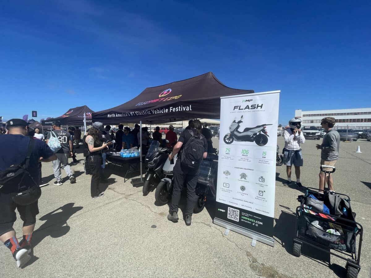 Alameda Post - A booth at an outdoor expo at Alameda Point showcasing mopeds or bikes.