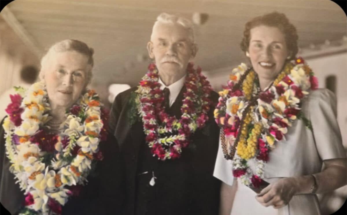 Alameda Post - A family photo of an older couple and their adult daughter. They wear colorful lower leis.