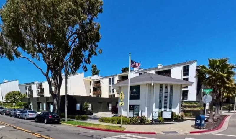 Alameda Post - A commercial or office building at South Shore Beach and Tennis Club. Behind the small building are large apartment buildings.