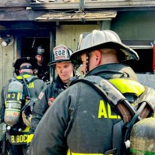 Alameda Post - firefighters with tanks and equipment enter a charred building