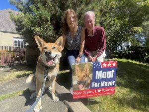 Alameda Post - Mouf the dog sits next to his campaign sign and two smiling people.