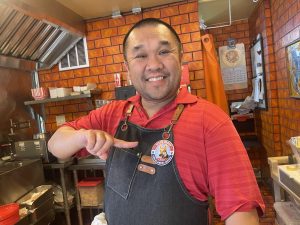 Alameda Post - Tony Yu behind the counter at the Papered Pup wears a sticker for Mouf's campaign.