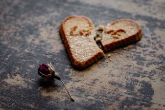 Alameda Post - a dried rose next to a broken cookie with the word "Love" on it. Divorce is never easy