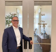Alameda Post - Alameda's new City Manger Gerry Beaudin stands by the City Manager door in city hall and smiles.
