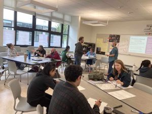 Alameda Post - an AUSD classroom with teachers or other adults sitting and working at large group desks