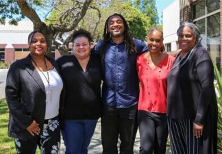 Alameda Post - five people of color who comprise the AUSD Office of Equity stand together and smile at the camera