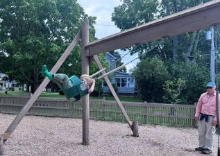 Alameda Post - A photo of a child playing on a swingset.