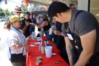 Alameda Post - People behind a table at the Rock and Roll Beer Stroll help attendees.